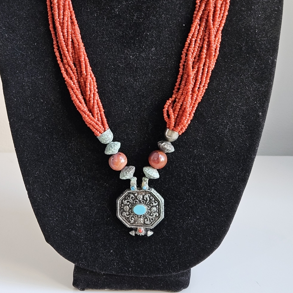 Vibrant Red Beaded Necklace with Intricate Silver Pendant